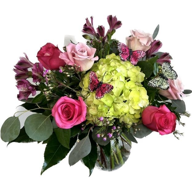 Bouquet featuring pink roses, green hydrangea, purple blooms, eucalyptus leaves, and butterfly decorations in a clear vase.